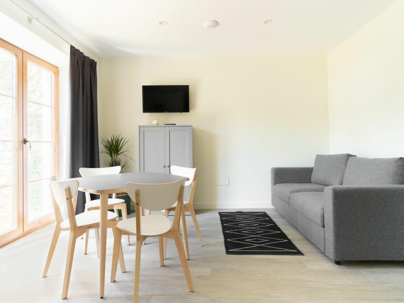 Salón-comedor del apartamento Galizano con mesa redonda, sofá y salida al jardín privado